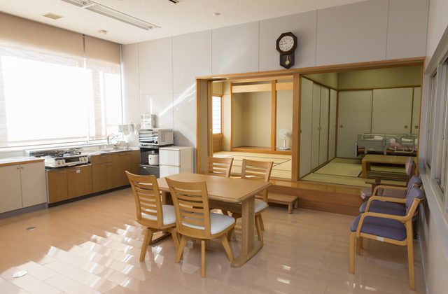 4階実習室の奥にある畳の部屋や食卓スペースなど完備された在宅を意識した実習スペースの写真